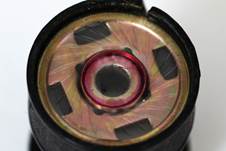 설명: A moving coil capsule: At the back of the transparent membrane you can see the wire coil, which is surrounded by a permanent magnet.